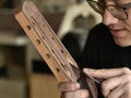 Luthier modifies the head of classical guitar. Royalty Free Stock Photo