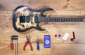 Luthier table top view with modern guitar and tools. Craftsman wooden desk flatlay view with rock metal electric guitar