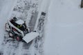 Lutsk, Ukraine - December 2, 2020. Bobcat skid steer loader removes snow from the city streets. Top view of the road with cars and Royalty Free Stock Photo