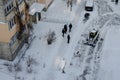 Lutsk, Ukraine - December 2, 2020. Bobcat skid steer loader removes snow from the city streets. Top view of the road with cars and Royalty Free Stock Photo