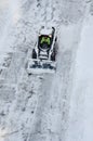 Lutsk, Ukraine - December 2, 2020. Bobcat skid steer loader removes snow from the city streets. Top view of the road with cars and Royalty Free Stock Photo