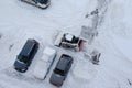 Lutsk, Ukraine - December 2, 2020. Bobcat skid steer loader removes snow from the city streets. Top view of the road with cars and Royalty Free Stock Photo