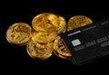 Lutsk, Ukraine - May 1, 2021: Golden coin with bitcoin logo and credit card by monobank. Crypto currency BTC and bitcoin