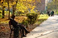 Lutsk, Ukraine - October 10, 2020. Young caucasian woman sitting on park bench and watching information on phone. Online work Royalty Free Stock Photo