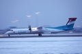 Luxair plane taxiing on runway, snow in winter