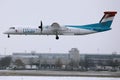 Luxair plane landing on runway, snow in winter