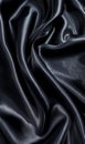 Luxe black satin fabric captured in undulating waves, creating a sense of movement.