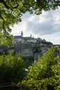 Luxembourg skyline and bridge framed by lush green summer trees