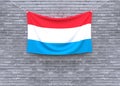 Luxembourg flag hanging on brick wall