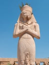 Luxor, Egypt - October 3, 2021: View of the statue of Ramses II in the Karnak temple against the background of the blue sky.