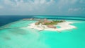 Flying a drone over a coral reef to a luxure resort island in the Maldives