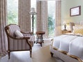 Luxurious armchair in a bedroom with wooden and soft elements in a classic style