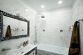 Luxurious bathroom with bath, shower, marble tiles and luxurious sink