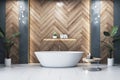 Luxurious bathroom interior with freestanding bath and herringbone wood wall.
