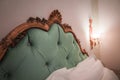 Luxurious and elegant bedroom with ornate headboard and bedside lamps at Palazzo Santa Maria