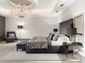 Luxurious bedroom with white walls and a gray fabric bed with black bedside tables and lamps and a large luminous crystal