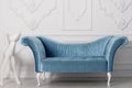 Luxurious blue velvet sofa and and white sculpture of a dog