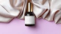 Luxurious bottle of perfume and beige silk on pink background, top view