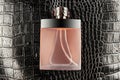 Luxurious bottle of perfume on black crocodile skin texture