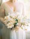 Luxurious bouquet of flowers in the hands of the bride. Cropped. Faceless
