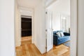 Luxurious corridor design with open white doors leading to the living room