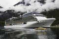 A luxurious cruise ship anchored near a Norwegian fjord village Flam during the summer months