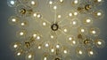 Luxurious crystal chandelier on the ceiling. Bottom view. Close-up. Huge crystal gold chandelier with candles. Royalty Free Stock Photo