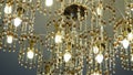 Luxurious crystal chandelier on the ceiling. Bottom view. Close-up. Huge crystal gold chandelier with candles. Royalty Free Stock Photo