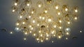 Luxurious crystal chandelier on the ceiling. Bottom view. Close-up. Huge crystal gold chandelier with candles. Royalty Free Stock Photo