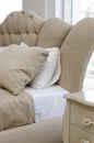 Luxurious double bed with upholstered headboard, close-up. Classic bedroom interior