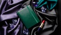 Luxurious emerald leather notebook surrounded by sparkling amethyst gems and ruby lipstick on rich silk fabrics Royalty Free Stock Photo
