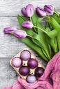 Luxurious fresh fashionable purple tulips on a wooden background next to Easter eggs Royalty Free Stock Photo