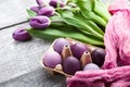 Luxurious fresh fashionable purple tulips on a wooden background next to Easter eggs Royalty Free Stock Photo