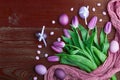 Luxurious fresh fashionable purple tulips on a wooden background next to Easter eggs Royalty Free Stock Photo