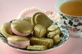 Luxurious gold French macarons and chocolates on a porcelain plate