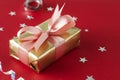 Luxurious gold gift box with pink ribbon, isolated on red background. Christmas, party, birthday background Royalty Free Stock Photo