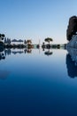 Luxurious hotel with swimming pool, palm trees, sun loungers Royalty Free Stock Photo