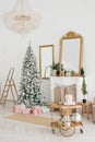 The luxurious interior of the living room with a fireplace and a Christmas tree, gifts and a stepladder. Classic interior in white Royalty Free Stock Photo