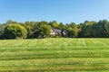 Luxurious large brick single family house surrounded by trees with a large green lawn. Landscape on a summer sunny day Royalty Free Stock Photo