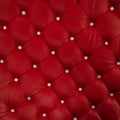 Luxurious leather soft sofa close-up. Stylish red material is decorated with brilliant buttons