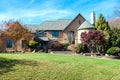 luxurious modern house with yellowed trees. Beautiful autumn landscape. Yard with green grass and landscaping