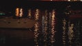 Luxurious modern private yacht and boat at the pier at night. Colorful lights of city glow shine reflected in water wave