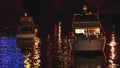 Luxurious modern private yacht and boat at the pier at night. Colorful lights of city glow shine reflected in water wave