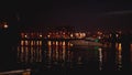 Luxurious modern private yacht and boat at the pier at night. Colorful lights of city glow shine reflected in water wave