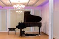 Luxurious music room with grand piano and chandelier with colorful lighting. Royalty Free Stock Photo