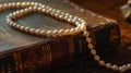 Luxurious pearl necklace creates a contrast with the rich texture of an antique book