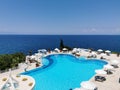 Luxurious pool with blue water and sea views. Sun loungers and umbrellas near the pool in the resort of Kusadasi, Turkey Royalty Free Stock Photo