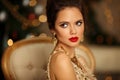 Luxurious portrait of elegant woman with wedding hairstyle and makeup. Beautiful brunette girl with golden jewelry in prom dress