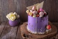 Luxurious Purple cake decorated with a bise, marshmallow, berries and fresh flowers.