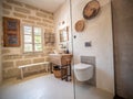 Luxurious and rustic bathroom, stone floor, large open shower and white toilet